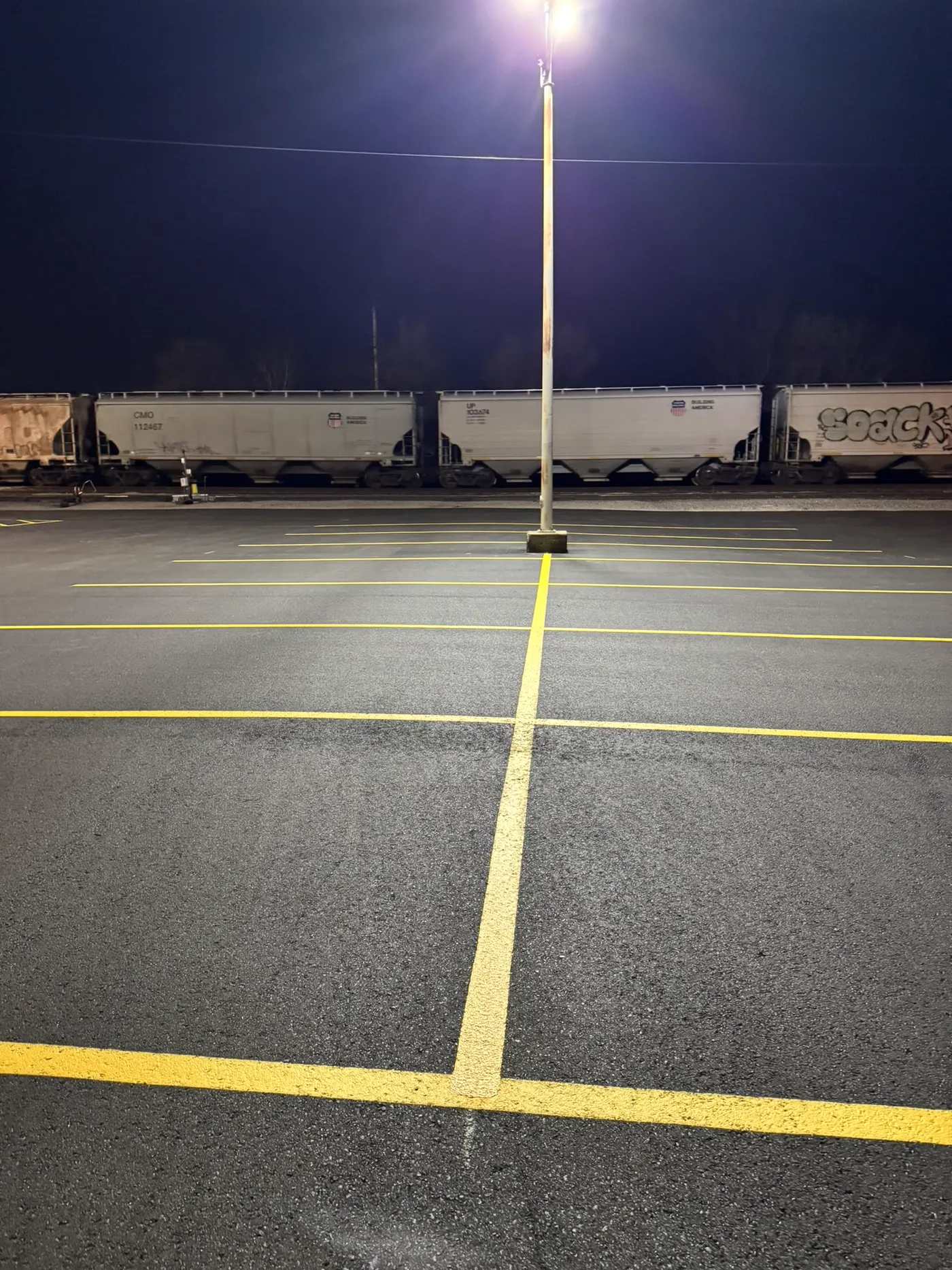 Fresh asphalt overlay being laid at Union Pacific Railroad parking lot in Topeka, Kansas